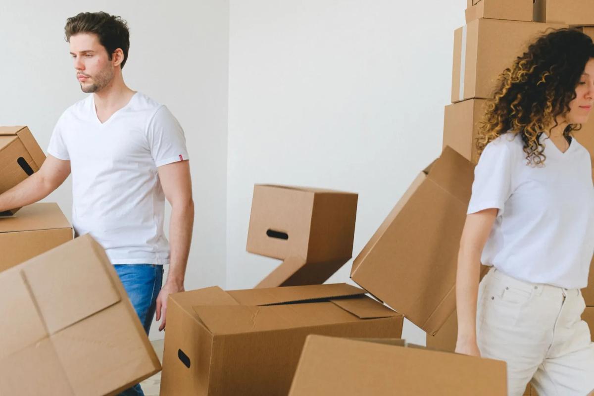 Jeune actif emménageant dans son appartement avec des cartons