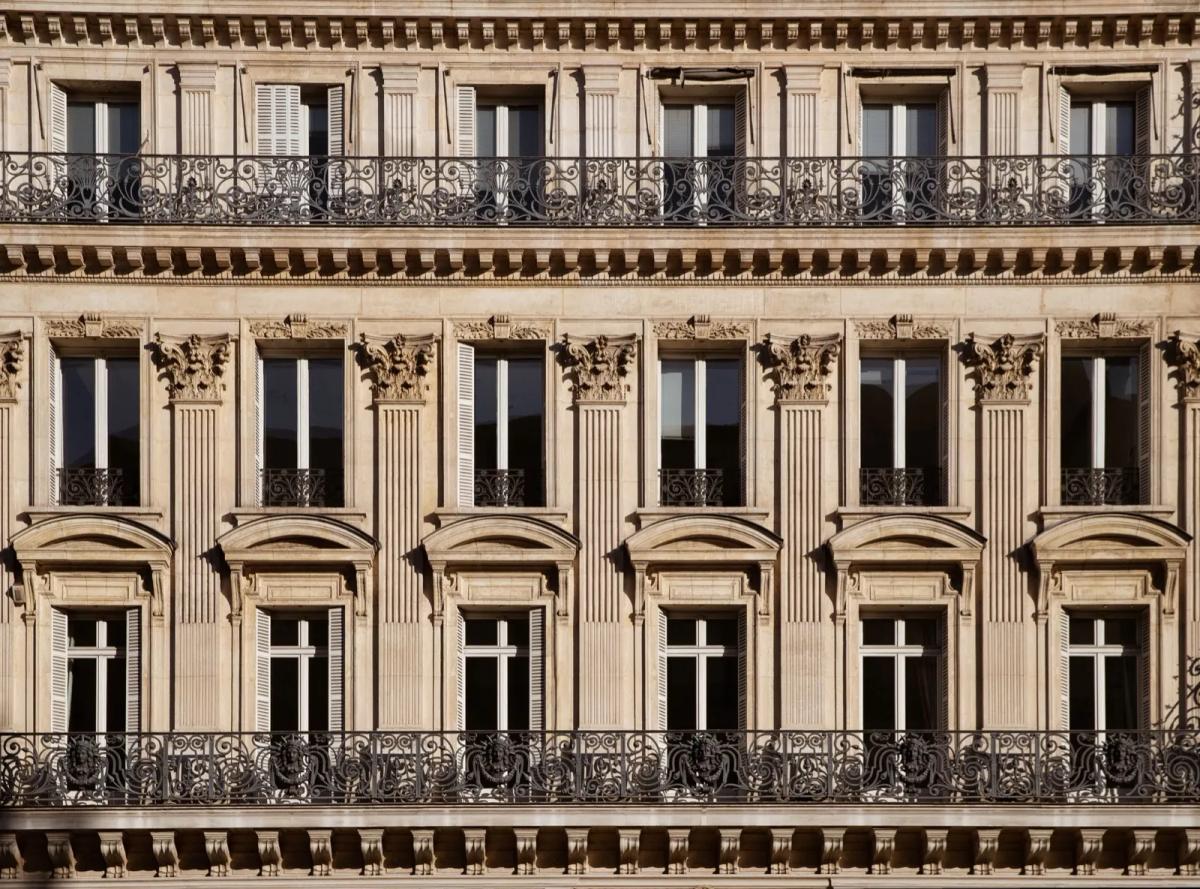 Vue d'un immeuble parisien haussmannien illustrant l'impact du bâti sur les charges locatives