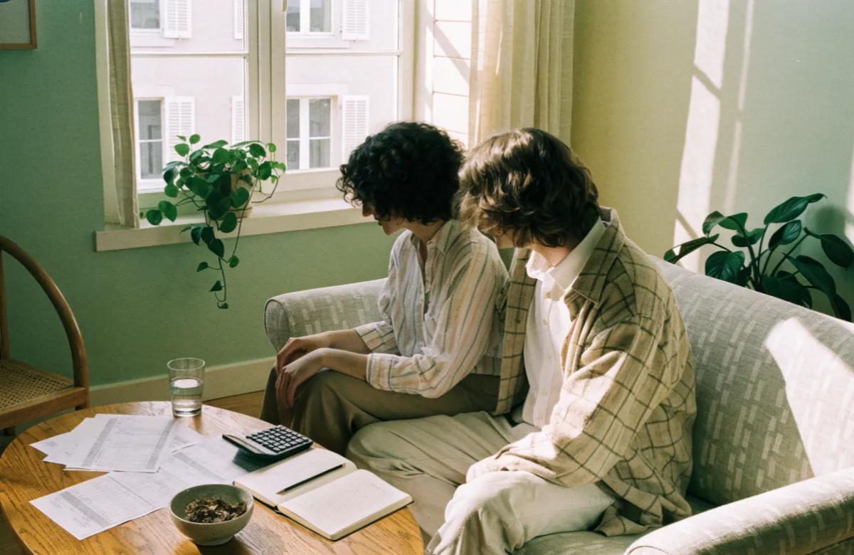 Couple examinant ensemble ses documents budgétaires et son loyer à la maison