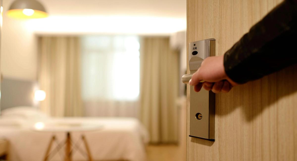 Locataire réalisant un état des lieux d'entrée avec son propriétaire, téléphone en main pour photographier les anomalies