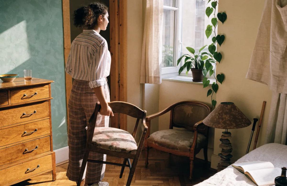 Jeune adulte aménageant son premier appartement avec des meubles d'occasion