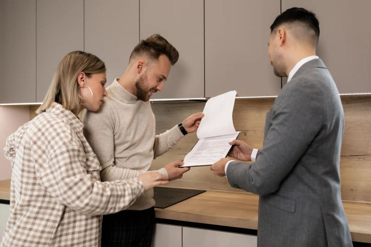 Locataire remettant son dossier de location avec attestation de paiement des loyers à un propriétaire