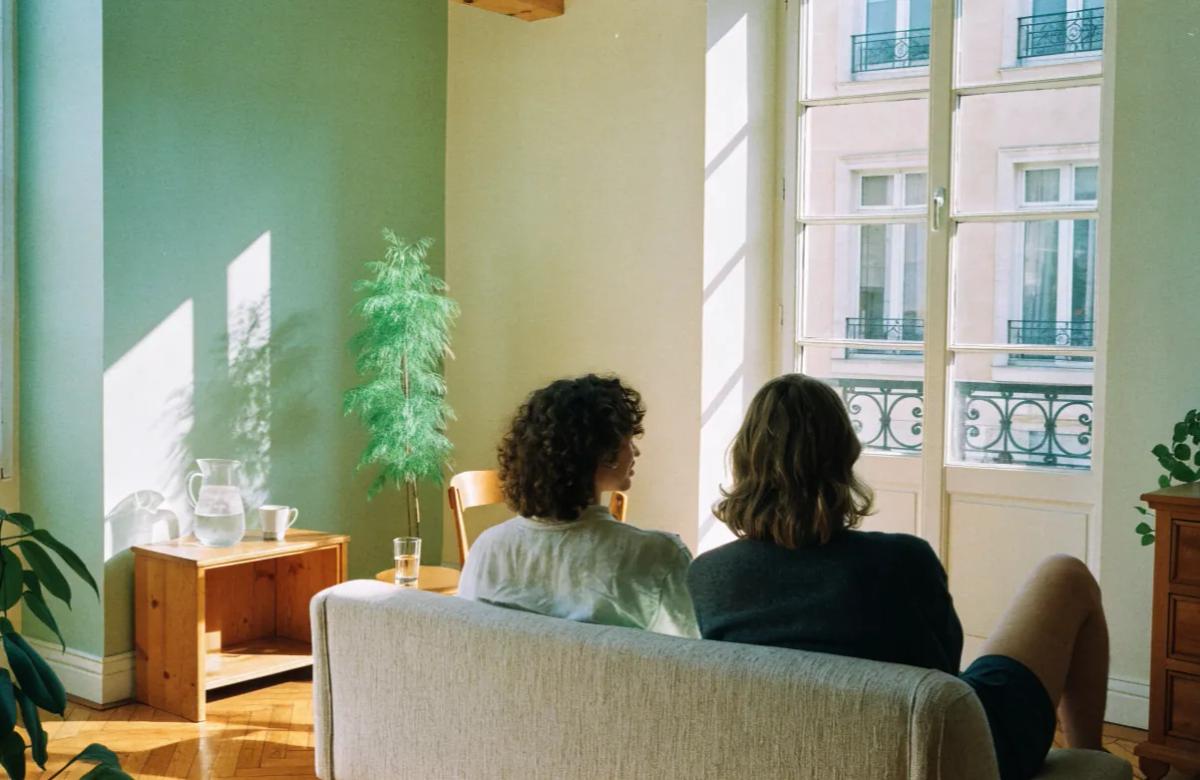 Colocataires partageant le salon lumineux d'un appartement à Paris