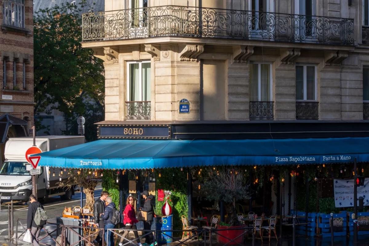 Rue animée d'un quartier parisien avec cafés et terrasses, idéale pour une colocation