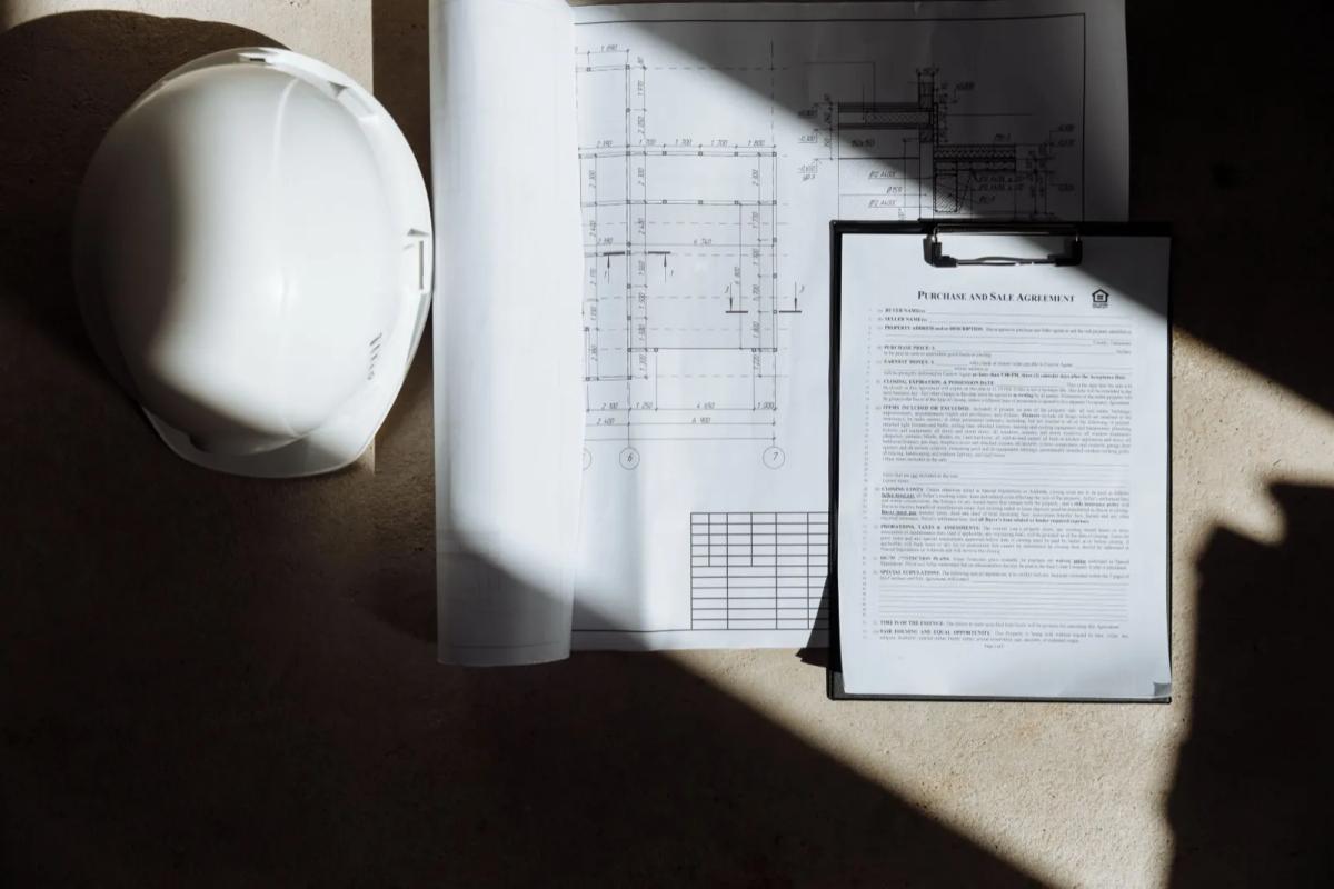 Document de règlement de copropriété ouvert sur une table avec plan d'immeuble