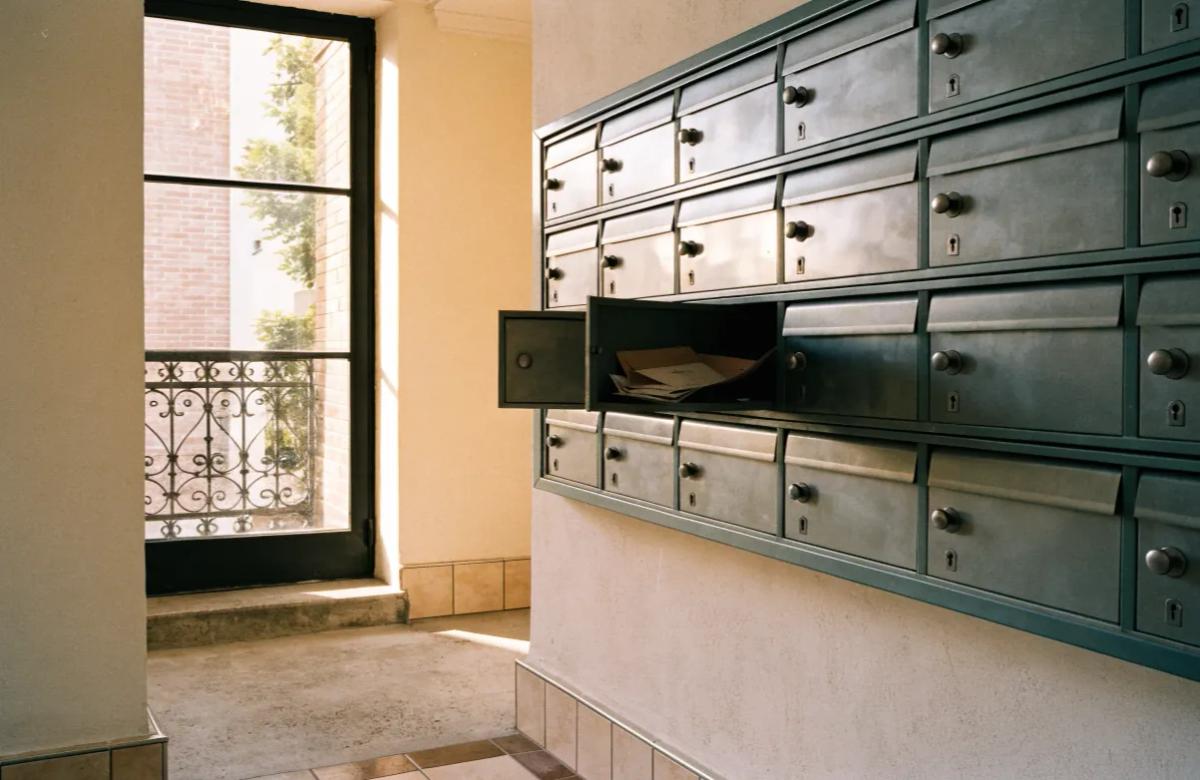 Boîte aux lettres ouverte contenant du courrier dans le hall d'un immeuble