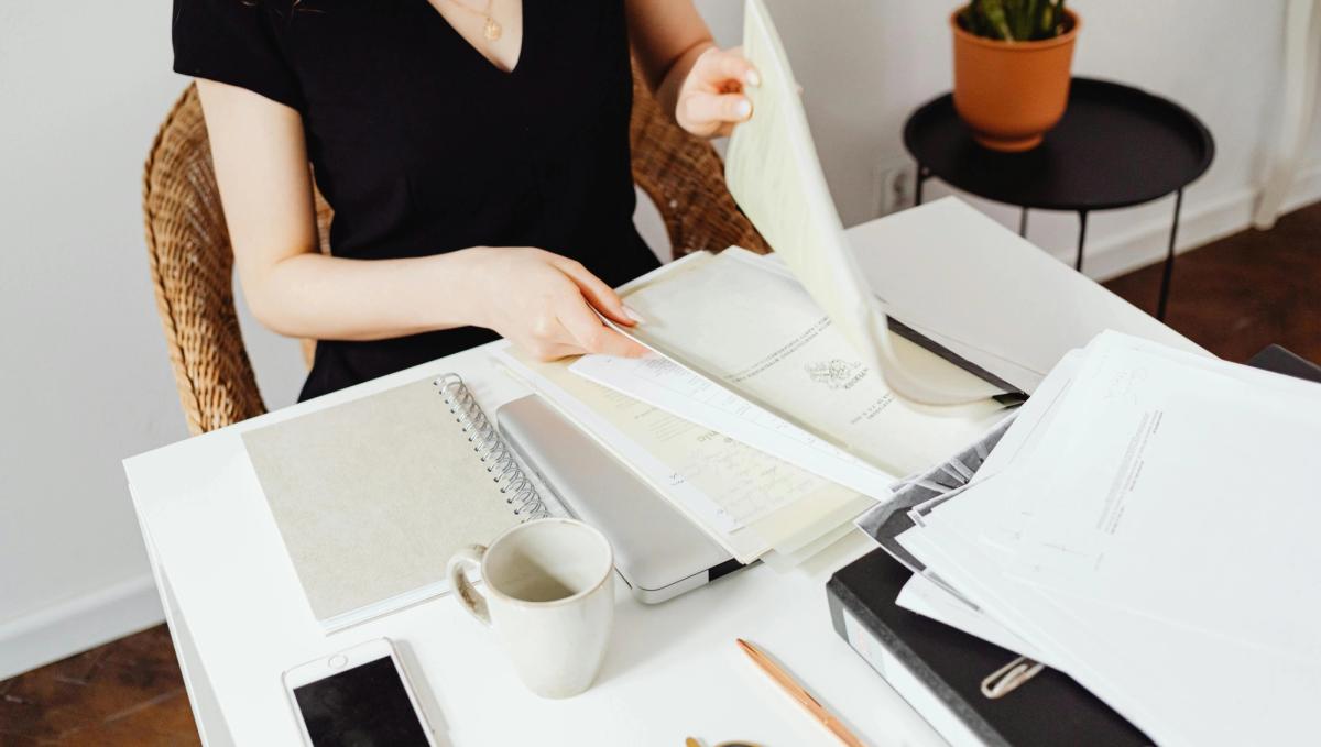 Freelance qui prépare son dossier de location sur son bureau avec des documents administratifs