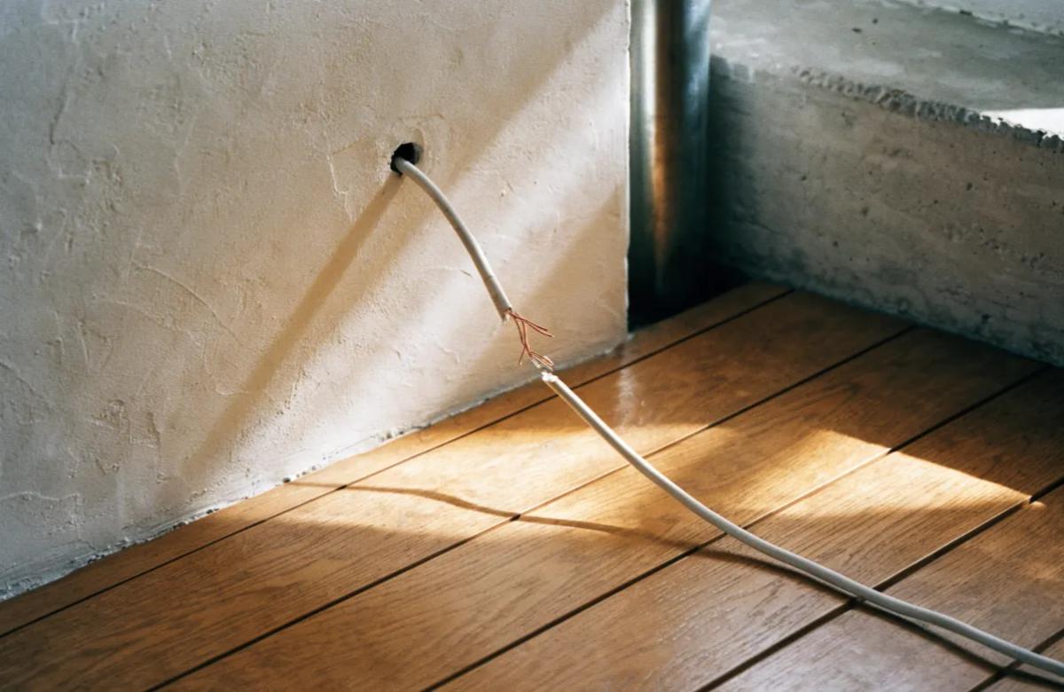 Câble électrique endommagé sortant d'un mur, dégât typique des rongeurs