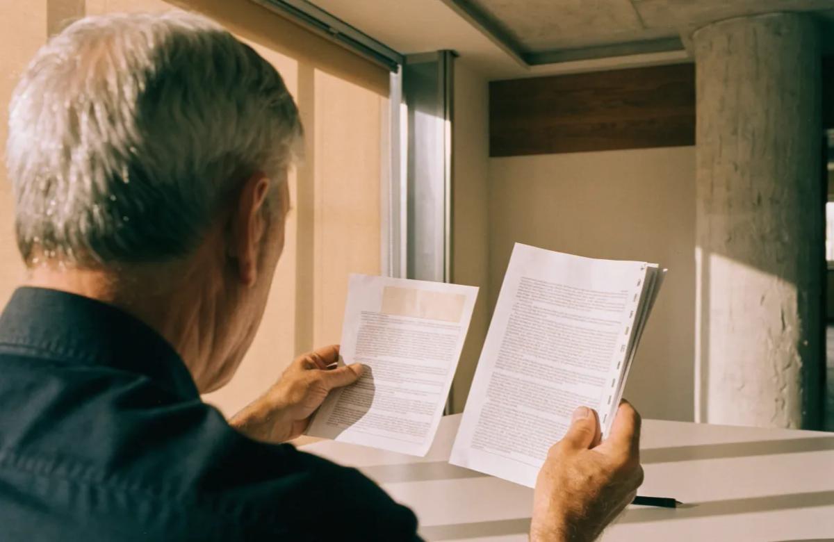 Propriétaire examinant un contrat de bail et une attestation d'assurance sur son bureau