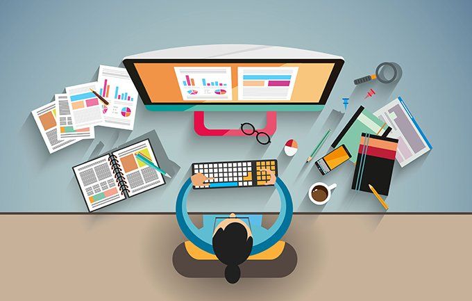 Designer working at a desk surrounded by website layout materials