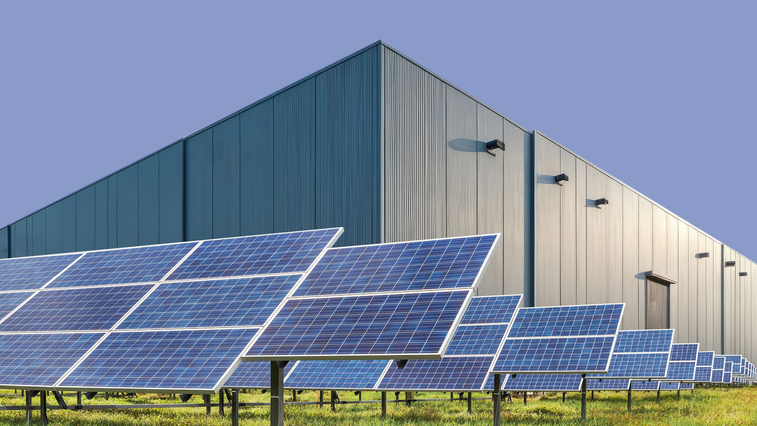Solar panels arrayed in front of a warehouse.