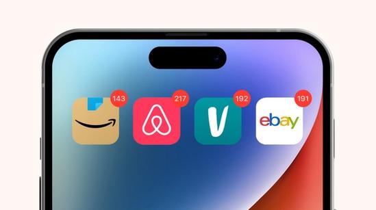 Close-up of a smartphone screen showing Amazon, Airbnb, Vinted, and eBay app icons, each with red notification badges displaying high numbers.
