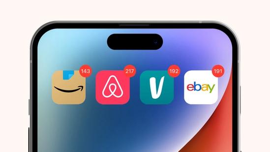 Close-up of a smartphone screen showing Amazon, Airbnb, Vinted, and eBay app icons, each with red notification badges displaying high numbers.