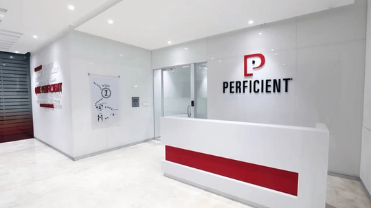 Reception area of Perficient with a white desk featuring a red accent, and the Perficient logo on the wall.