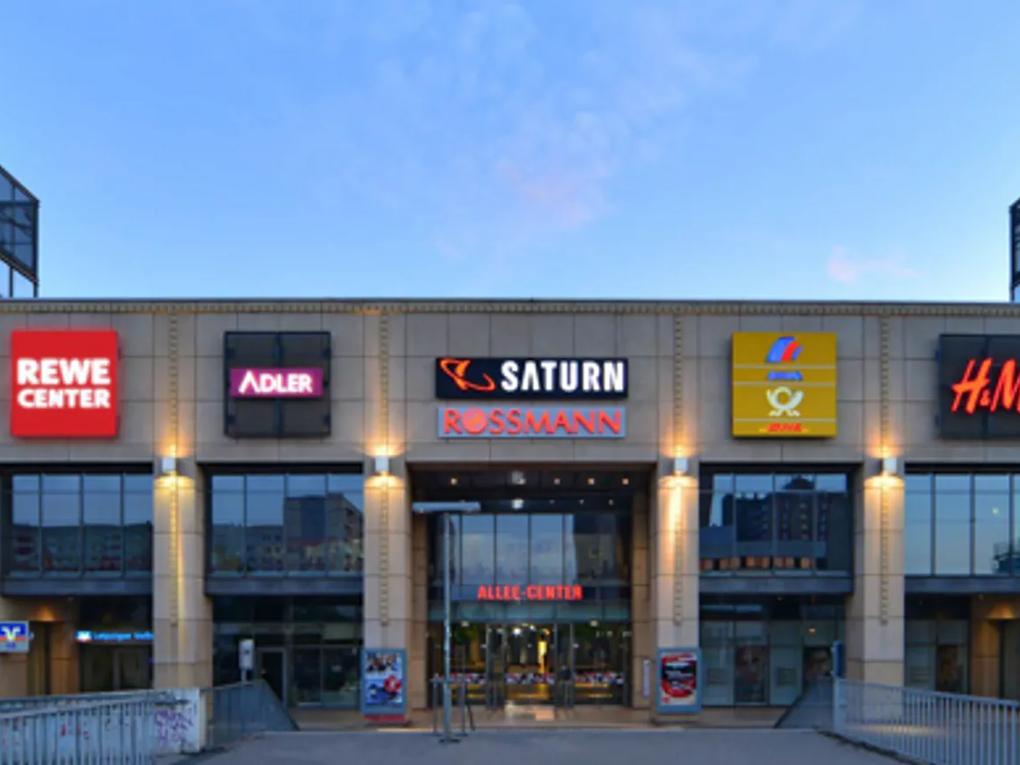 The front of a shopping center with various store signs.