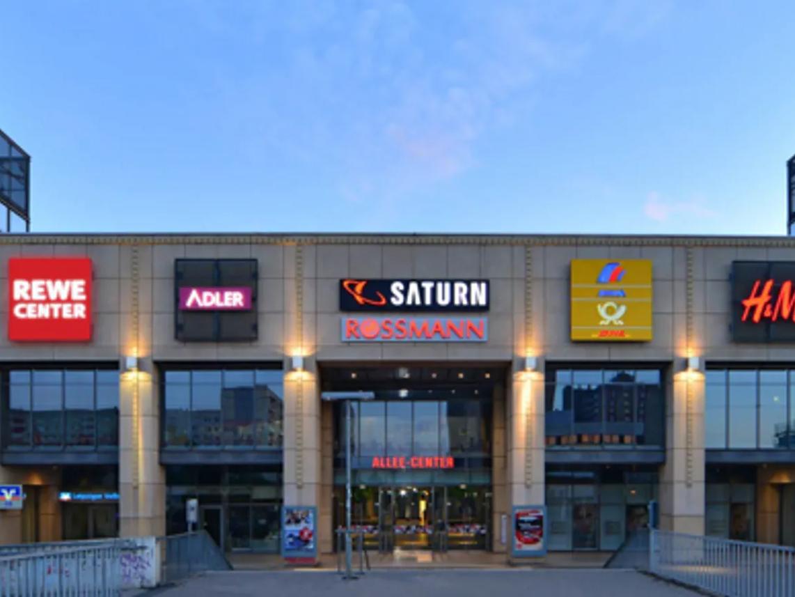 The front of a shopping center with various store signs.
