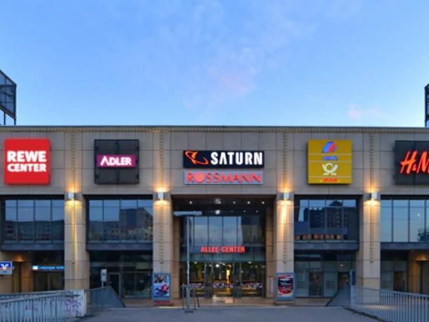 The front of a shopping center with various store signs.