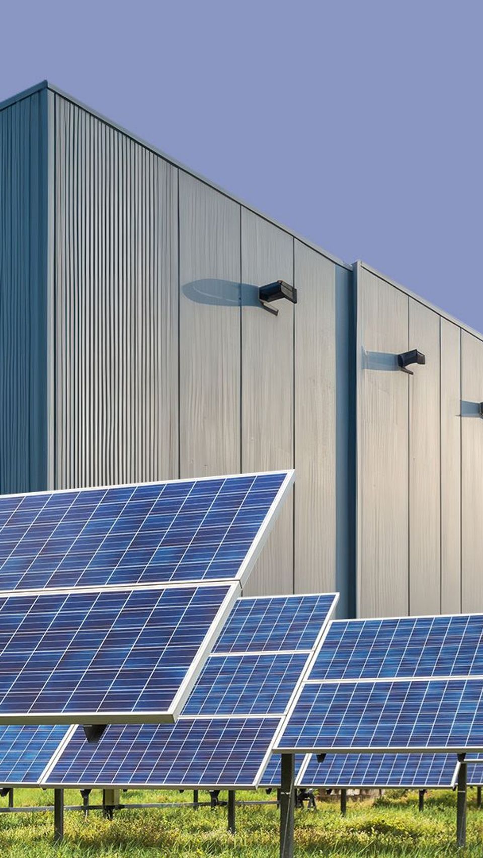 Solar panels arrayed in front of a warehouse.