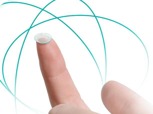 A close-up of a finger holding a contact lens.