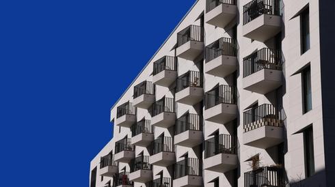 An apartment building against a blue sky.