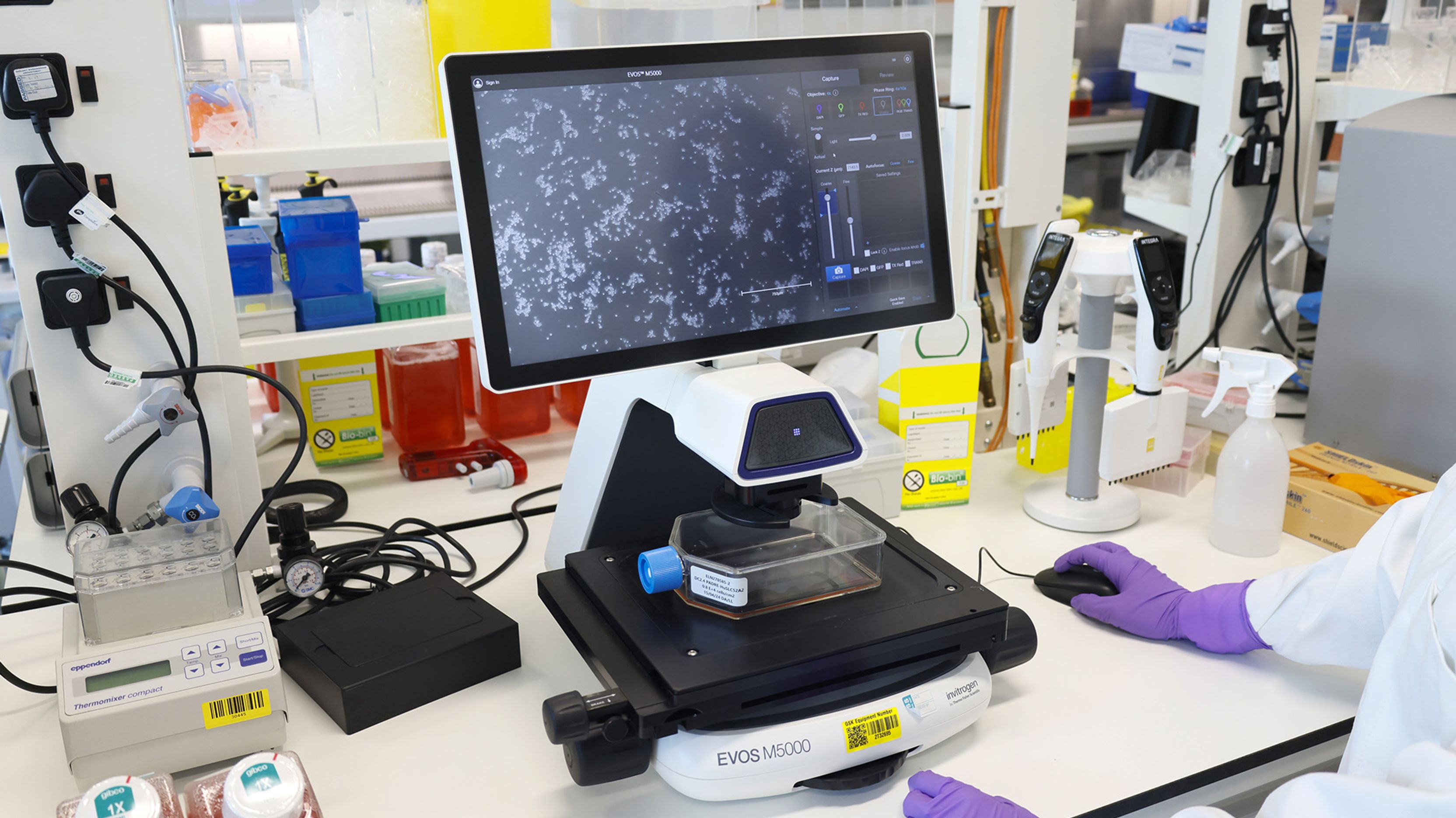 A clinician operates a piece of scientific equipment.