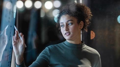 A woman points at a screen.