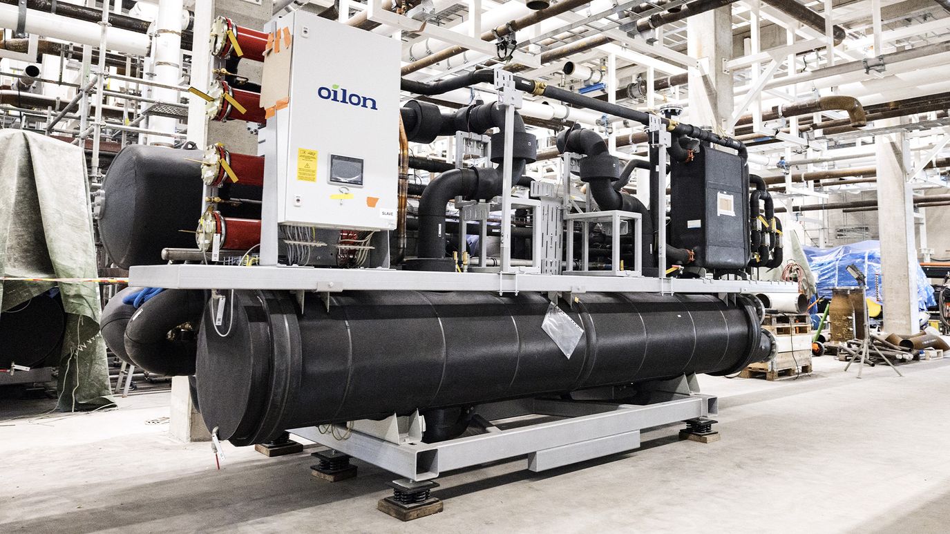 Industrial refrigeration or heat pump system with large black insulated pipes and an Oilon control unit installed in a mechanical plant room.