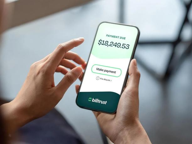 A person holding a smartphone displaying a payment app screen.