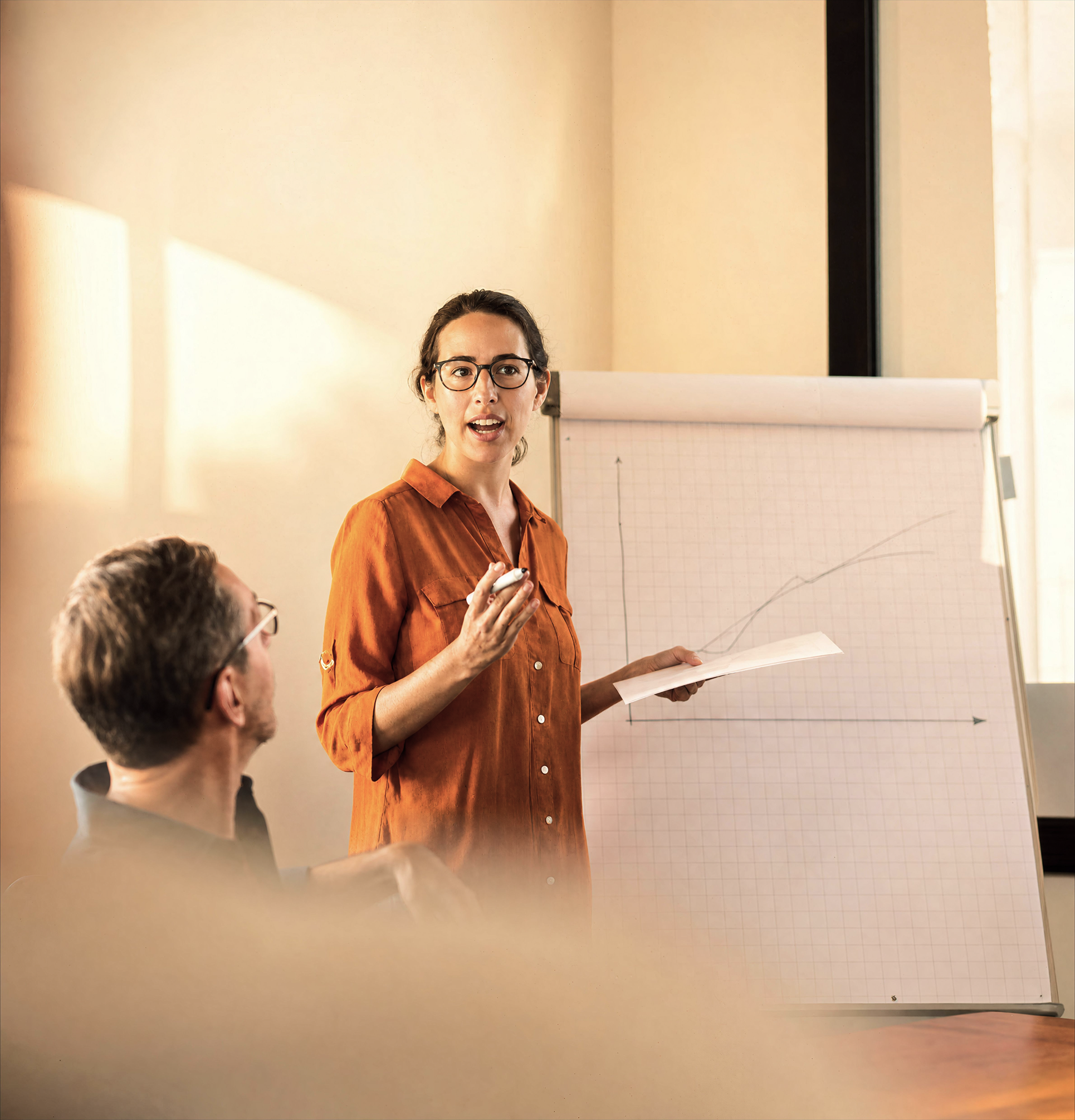 A woman holding a presentation with a graph