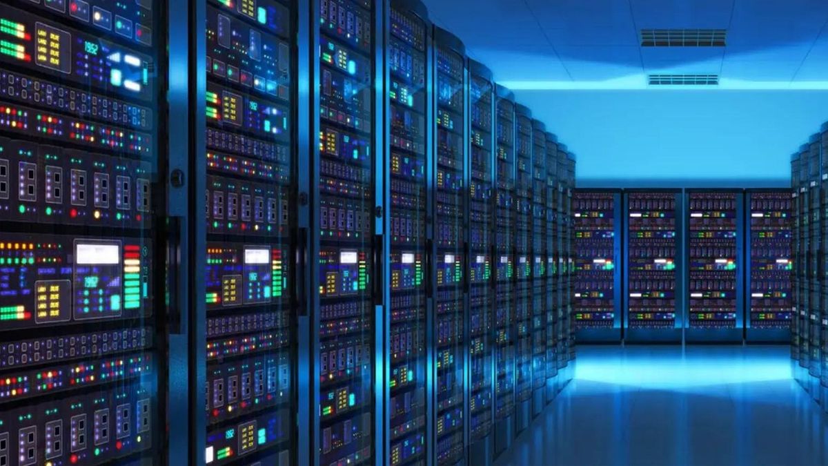 Long corridor of a data center with rows of server racks glowing with blue and multicolored indicator lights.