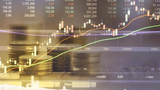 A financial chart with candlestick patterns and moving averages overlaid on stacks of coins.