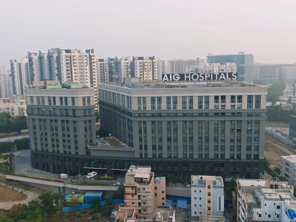 A large building labeled "AIG Hospitals" is in the foreground, surrounded by smaller buildings and high-rise apartments in the background.