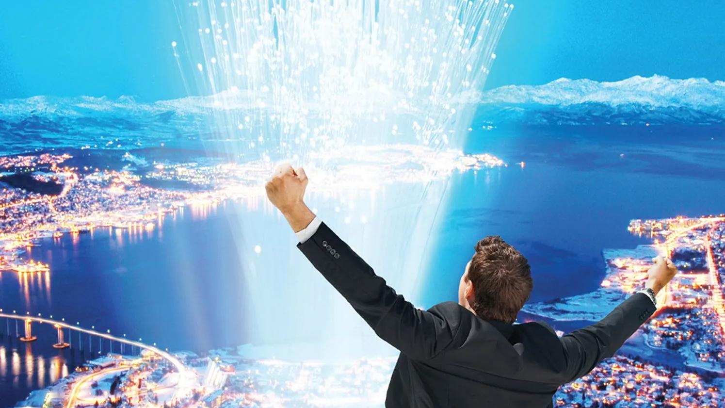 A person in a suit raising their arms triumphantly, overlooking a cityscape at night with illuminated buildings and roads, and a burst of light or data streams rising into the sky.