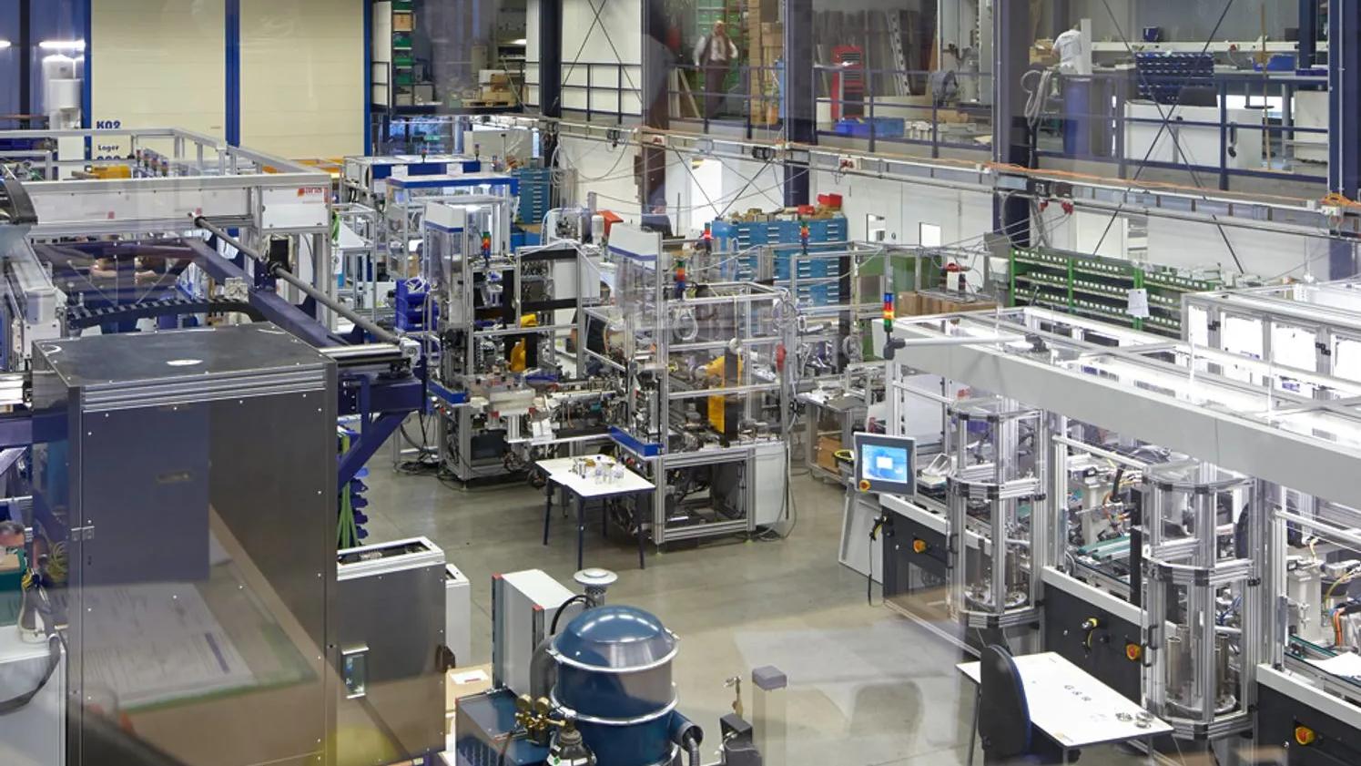 A large industrial facility with various machinery, workstations, and equipment, showcasing a complex manufacturing setup.