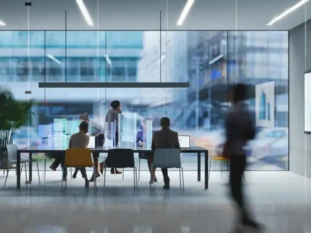 A modern office setting with people working at a table.
