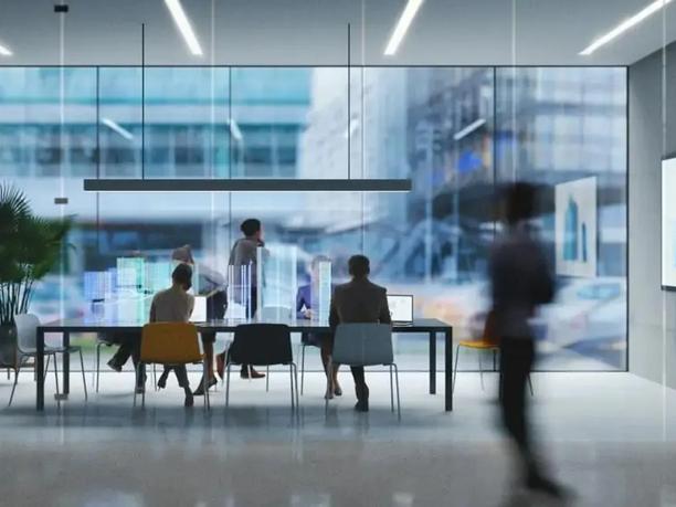 A modern office setting with people working at a table.