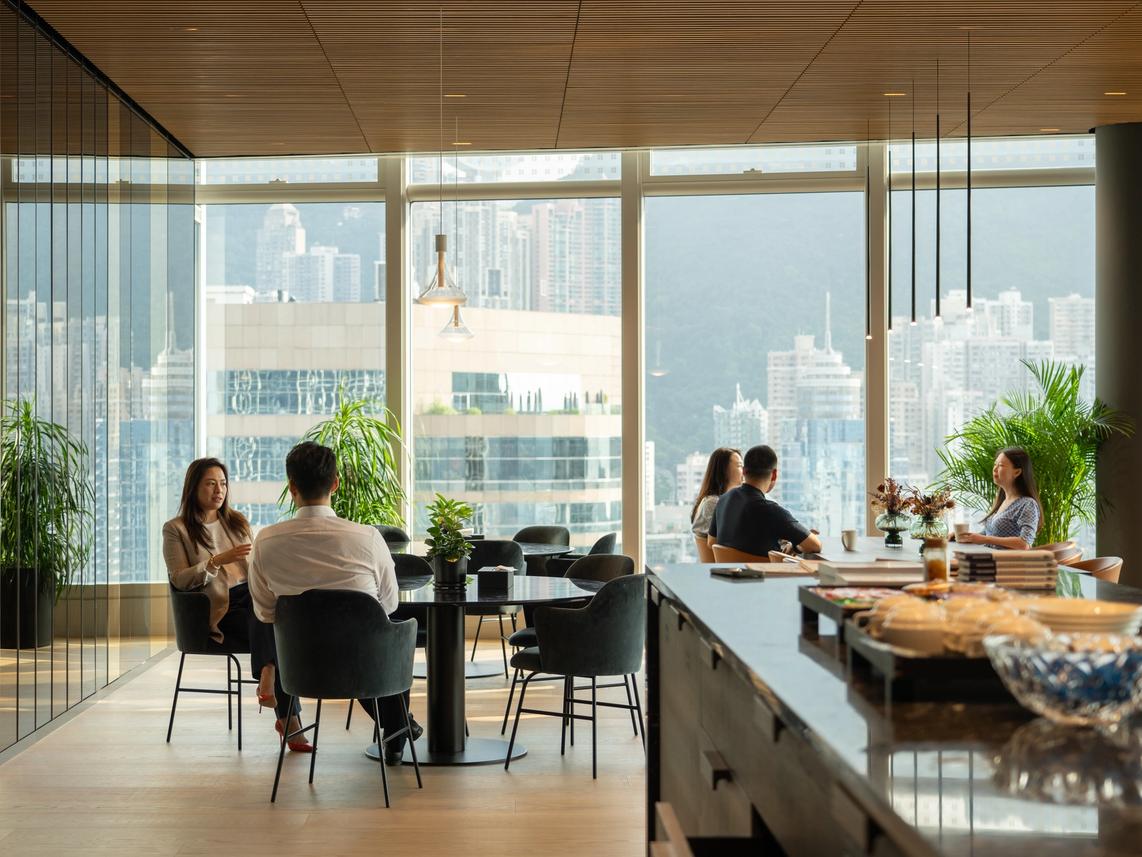 People in Office in front of large window