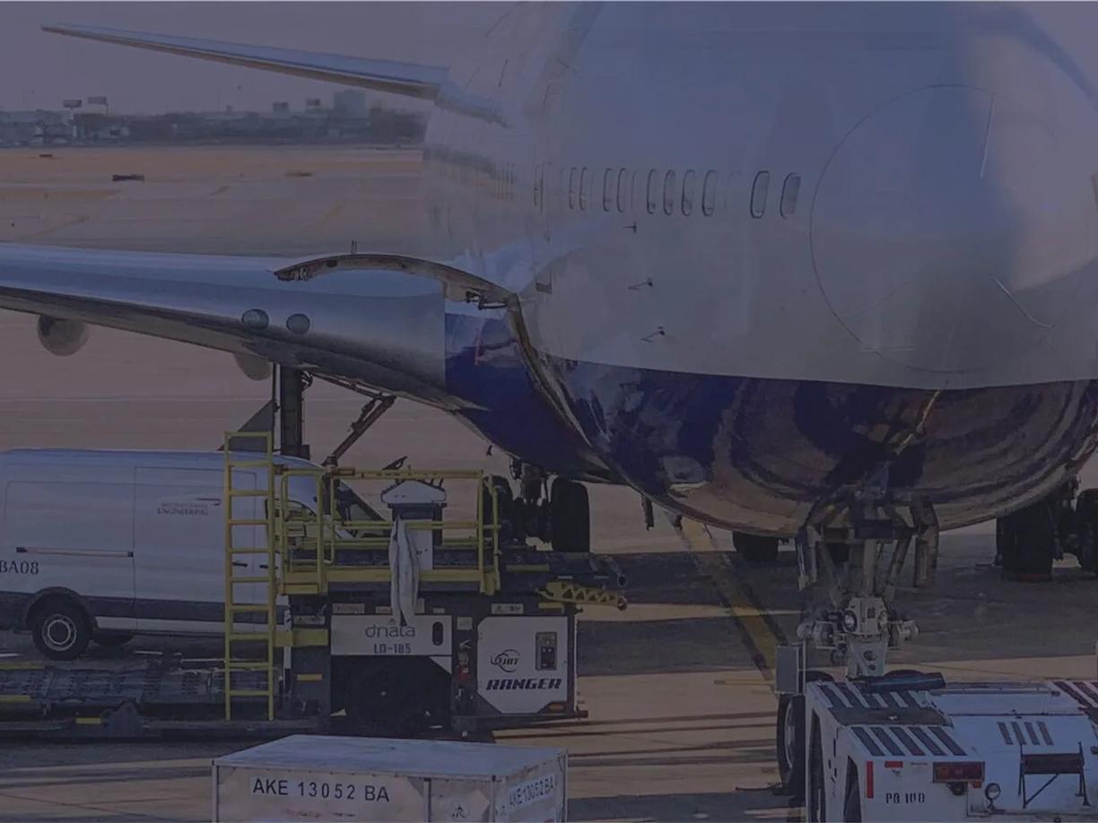 An airplane on the tarmac with cargo being loaded underneath.