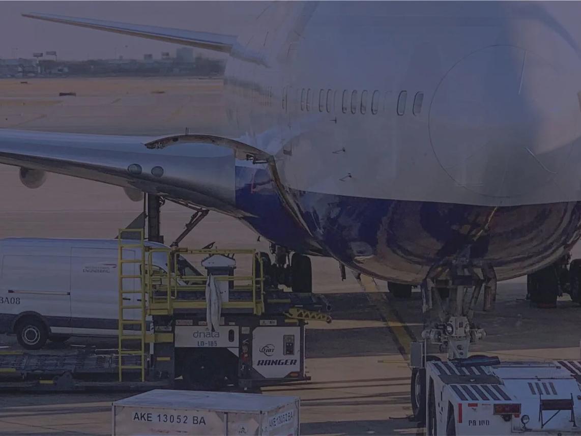 An airplane on the tarmac with cargo being loaded underneath.