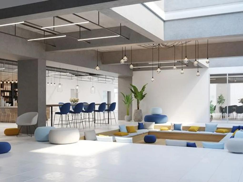 A modern, open office space with a sunken seating area filled with colorful cushions.