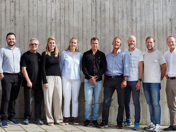 Nine people standing next to each other.