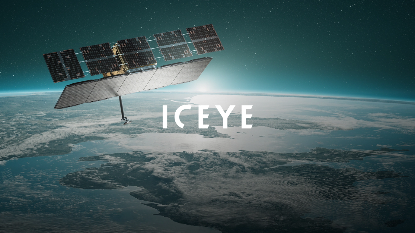 A satelite floating in space with the earth in the background, and with the logo "ICEYE".