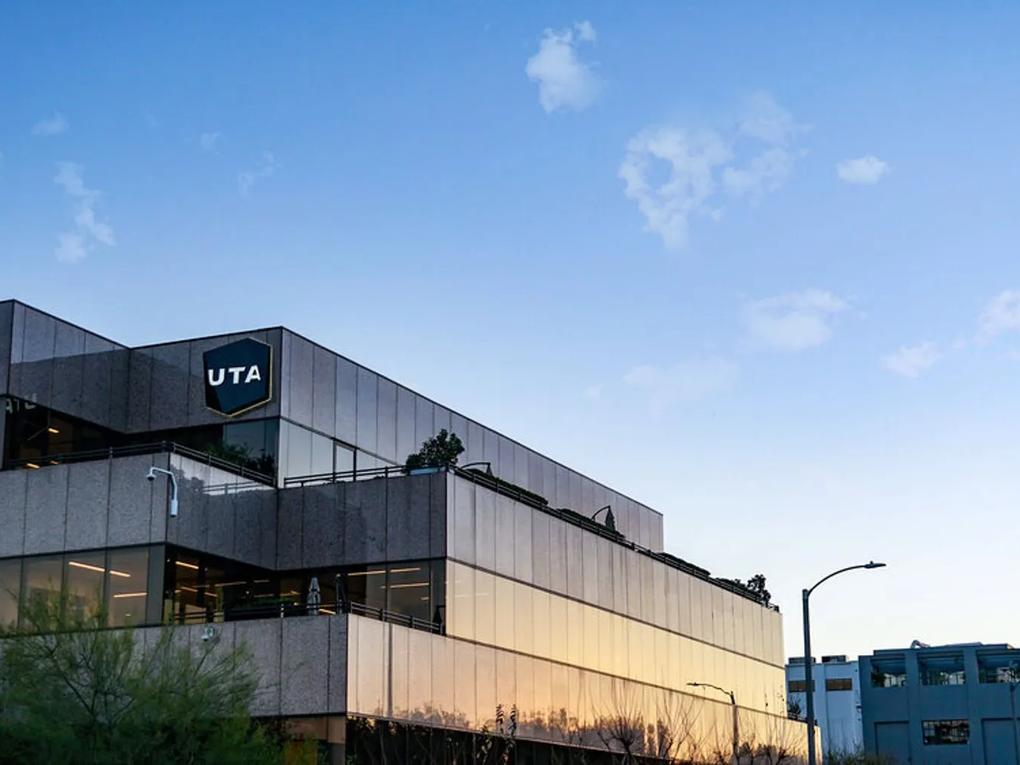 A modern office building with reflective glass windows, featuring a "UTA" logo on the corner.