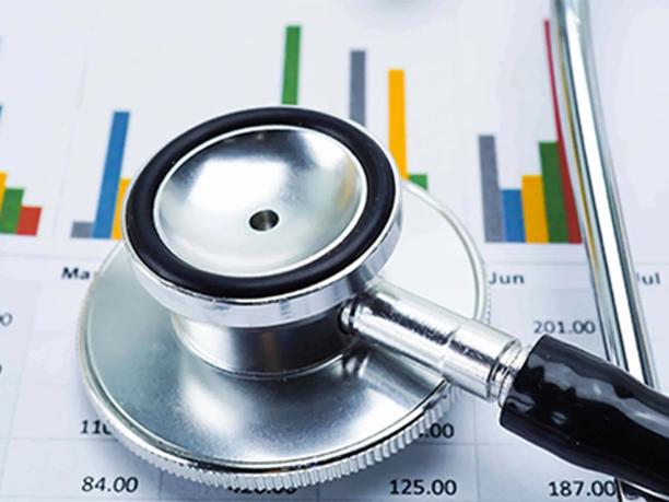 A stethoscope resting on a financial chart with colorful bar graphs.