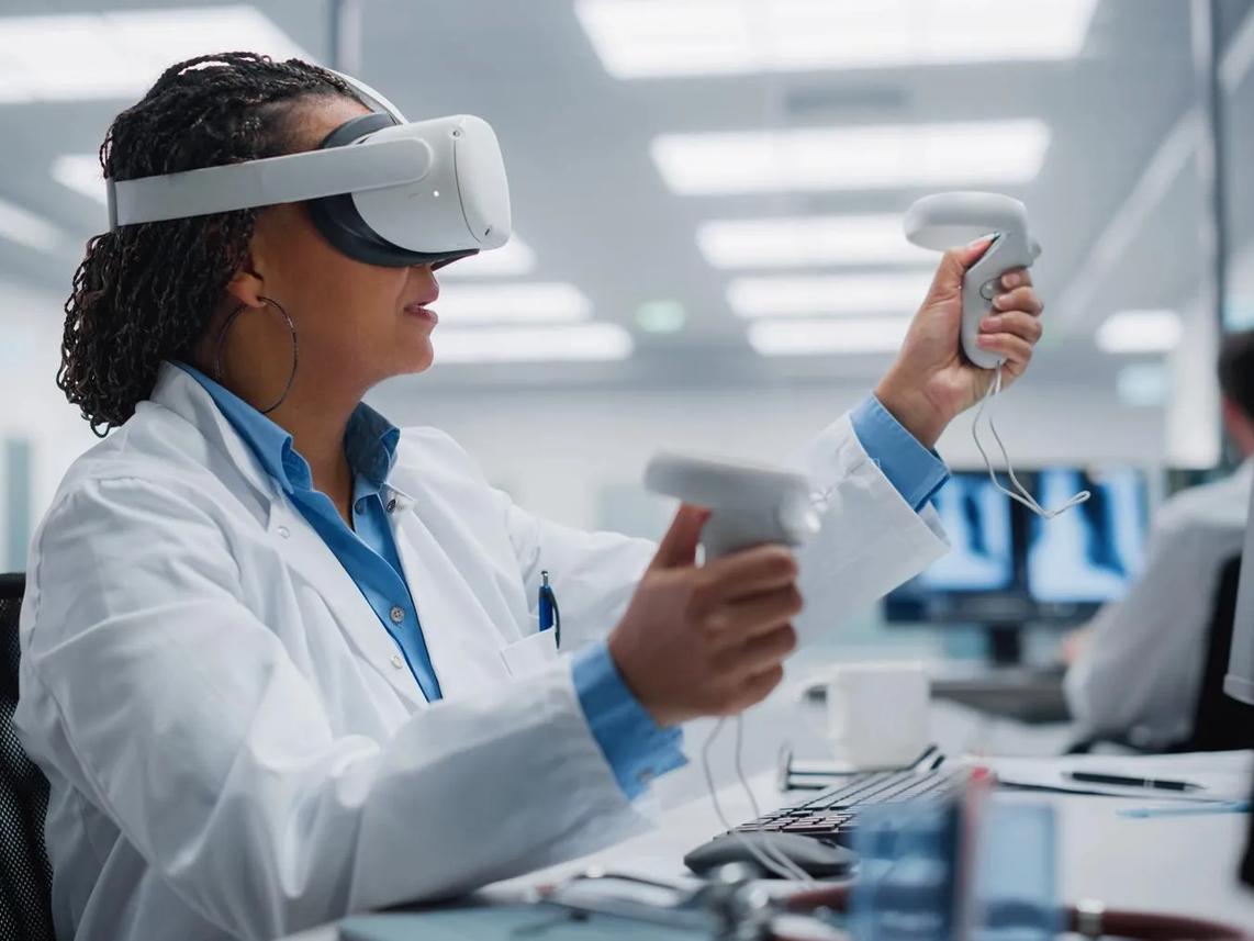 A person wearing a lab coat and virtual reality headset is using VR controllers in an office setting.