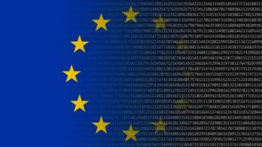 European Union flag with yellow stars mixed with computer text.