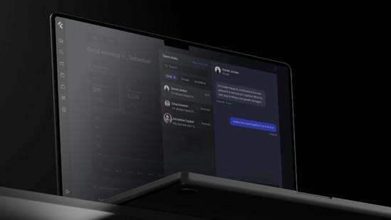 A laptop screen shows a team chat.