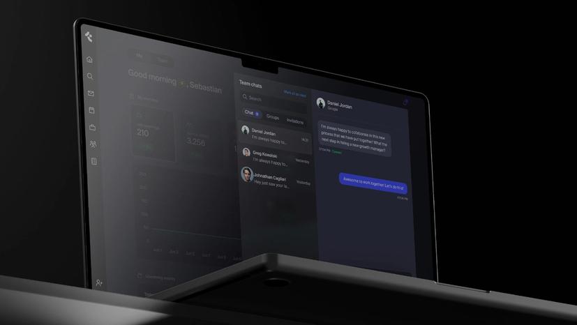 A laptop screen shows a team chat.