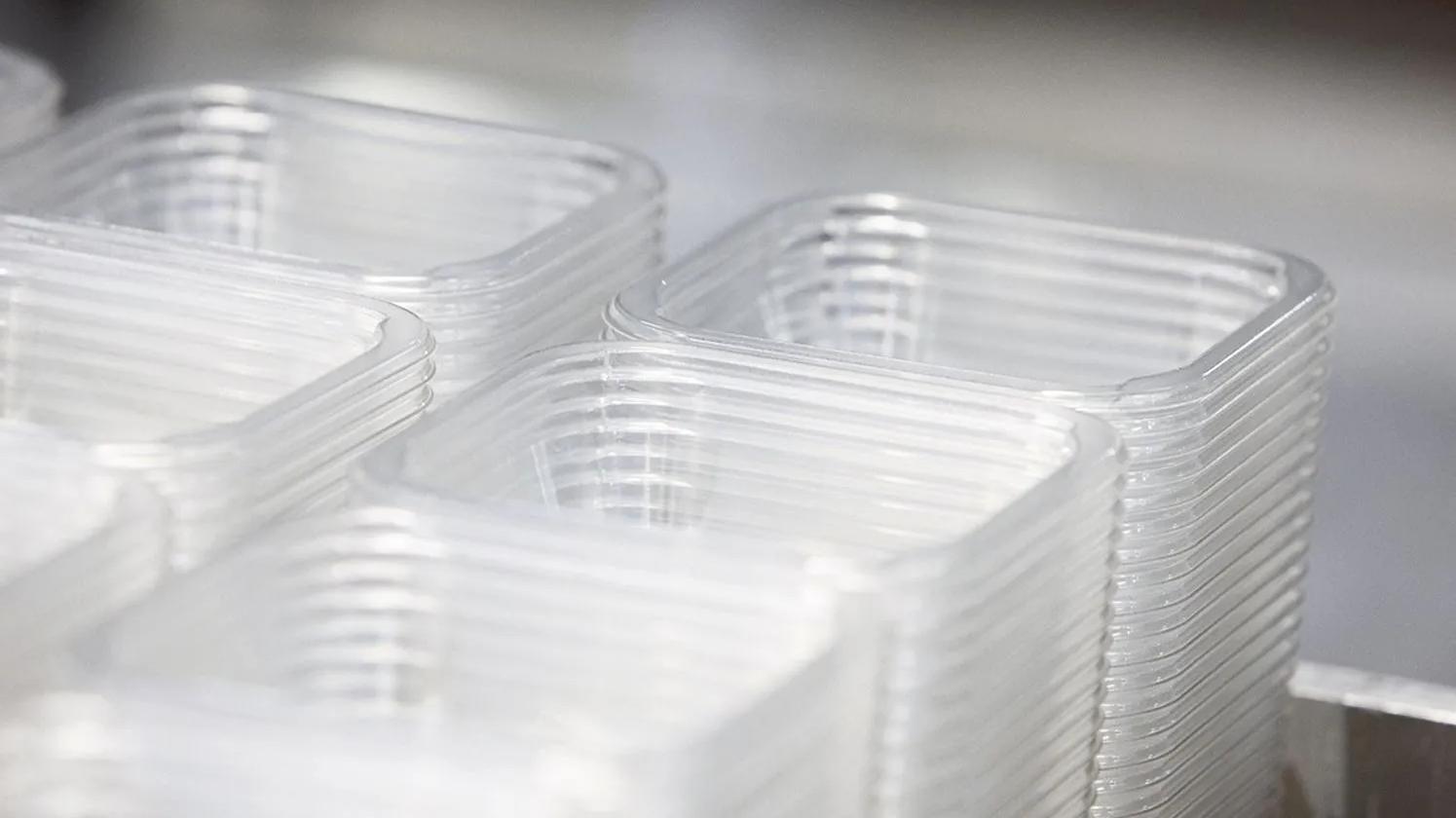 Stacks of clear, rectangular plastic containers arranged neatly, likely used for packaging or storage.