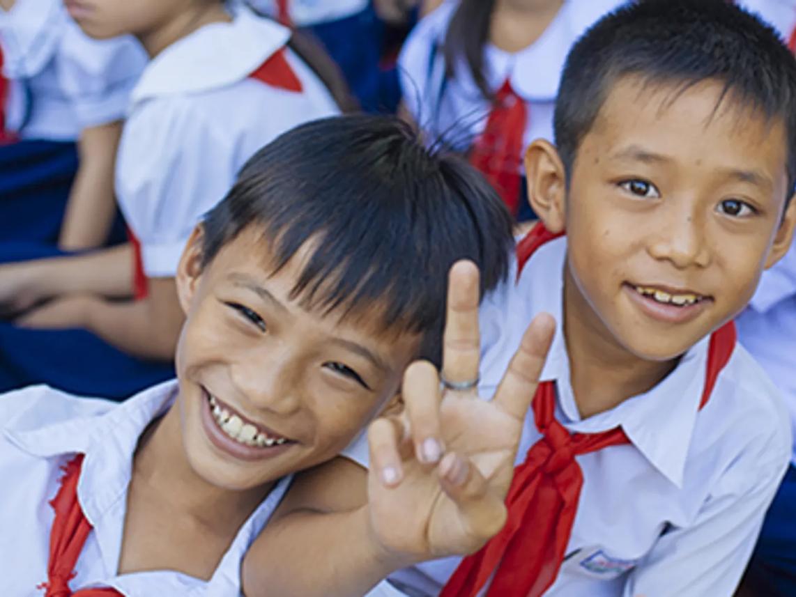 Two smiling children in school uniforms.
